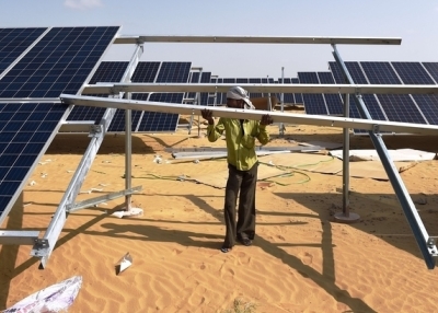 In this photograph taken on August 23, 2015, an Indian engineer fixes a solar panel into position at the under construction Roha Dyechem solar plant at Bhadla some 225 kms north of Jodhpur in the western Indian state of Rajasthan. (Money Sharma/Getty Images)