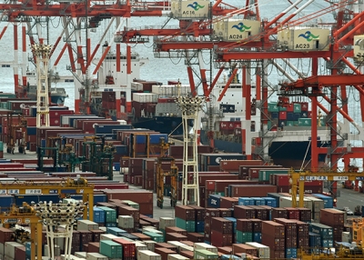 Gantry cranes and shipping containers are seen beside a vessel at the cargo terminal area of Tokyo port on October 6, 2015. Japanese Prime Minister Shinzo Abe hailed a deal to create the world's largest free trade area October 6 as the start of a 'new century' for Asia, and expressed hope China might one day join the historic accord. (Kazuhiro Nogi/AFP/Getty Images)