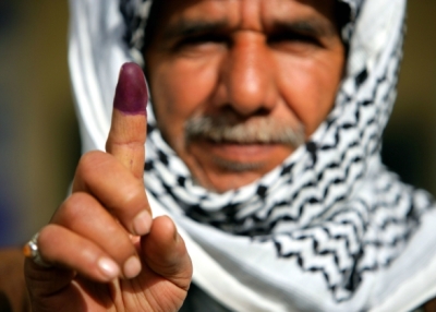 An Iraqi man in Najaf displays his finger to the camera on January 30, 2005 in Najaf, Iraq. The purple dye indicates that he has just voted in Iraq's first elections. (Brent Stirton/Getty Images)