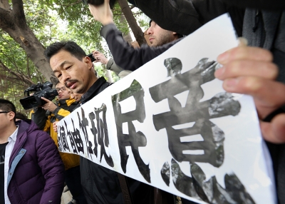 A protester whose banner reads “Freedom of the Press Reflects the Public’s Opinion” outside the Southern Media Group headquarters in Guangzhou on January 9, 2013. (AFP/Getty Images)