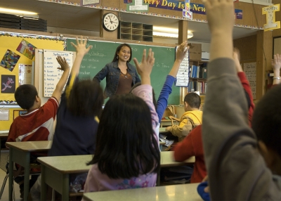 Students raise their hand in a classroom