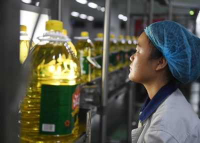 A Chinese worker examines a bottle of soybean oil