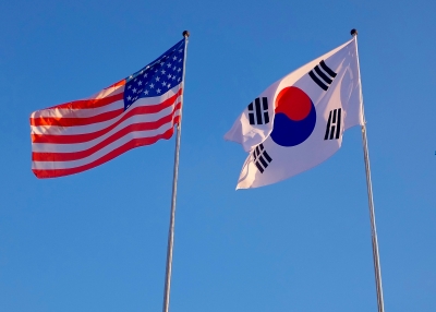 U.S. and South Korean flags against a blue sky