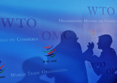 Two silhouettes on a blue backdrop at the World Trade Organization