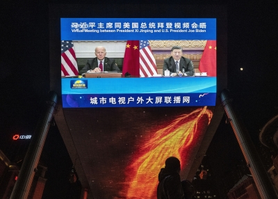: A large screen displays United States President Joe Biden, left, and China's President Xi Jinping during a virtual summit as people walk by during the evening CCTV news broadcast outside a shopping mall on November 16, 2021 in Beijing, China.