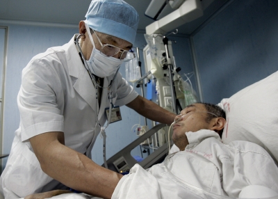 China's top Severe Acute Respiratory Syndrome (SARS) expert Zhong Nanshan checks on one of his patients during his rounds in the infectious disease ward, at the Guangzhou Institute of Respiratory Diseases 10 June 2005, in Guangzhou, southern China's Guangdong province.