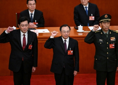 (L-R) Newly-elected Chinese state councilor Qin Gang, state councilor and secretary-general of the State Council Wu Zhenglong, state councilor Li Shangfu swear an oath after they were elected during the fifth plenary session of the National People's Congress (NPC) at the Great Hall of the People in Beijing on March 12, 2023.