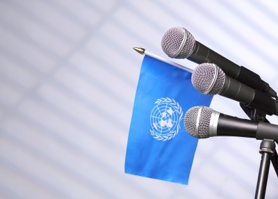 The flag of the United Nations, with media microphones