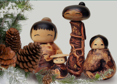 Wooden kokeishi dolls, pine cones, and greenery