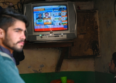 People monitor latest election results live on a television at a tea shop, a day after Pakistan's national elections in Lahore on February 9, 2024. Candidates linked to jailed former Pakistan prime minister Imran Khan were running a close race with the party of three-time premier Nawaz Sharif on February 9 as election results trickled in after a long delay that added to accusations of poll rigging.