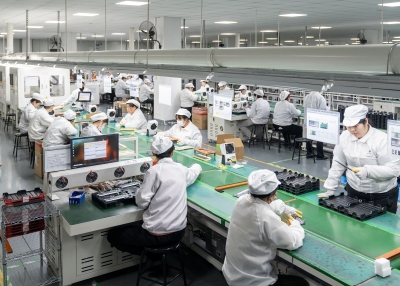 Employees work on a production line making batteries
