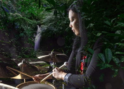 susie ibarra playing the drums superimposed over sky islands 