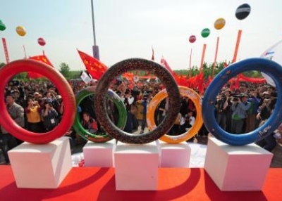 A display of rings attracts the attention of flag-waving participants at a Beijing walkathon celebrating in advance of the Olympics on April 26, 2008. (FREDERIC J. BROWN/AFP/Getty Images)