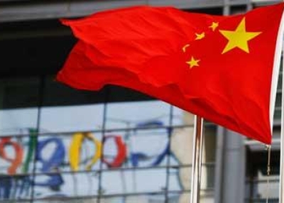 The Google logo is reflected in windows of the company's China head office as the Chinese national flag flies in the wind in Beijing on Mar. 23, 2010. (Li Xin/AFP/Getty Images)