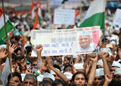 Supporters of the anti-corruption hunger strike by Indian activist Anna Hazare wave the national flag and hold up a fake Indian currency note depcting a portrait of Hazare during a rally in New Delhi on August 21, 2011. (Sajjad Hussain /AFP/Getty Images)  