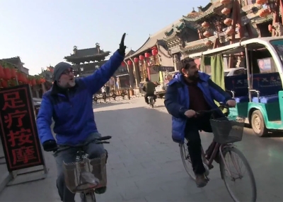 Howie Southworth (left) and Greg Matza ride through Ping Yao.