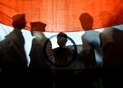 Supporters of anti-corruption activist Anna Hazare stand behind the national flag of India as they celebrate the 12th day of Hazare's hunger strike in New Delhi on Aug. 27, 2011. (Manan Vatsyayana/AFP/Getty Images)