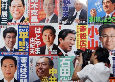 A journalist photographs Democratic Party of Japan campaign posters outside the Laforet Museum Roppongi in Tokyo, August 30, 2009. (Junko Kimura/Getty Images)