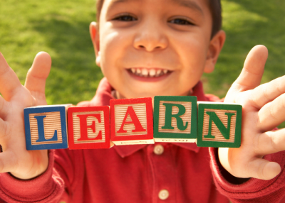 A child with blocks spelling LEARN. (marsbars/istockphoto)