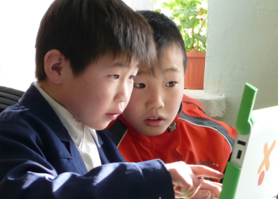 Students in Ulaanbaatar checking collaborating on an XO laptop. Photo: one laptop per child/flickr.com.