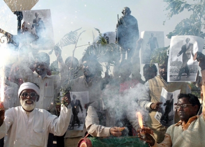 Indian tribal organisation activists from Jarkhand state light fireworks and hold up portraits of US president-elect Barack Obama as they celebrate in front of a statue of Mahatma Gandhi in Ranchi on November 5, 2008. (STR/AFP/Getty Images)