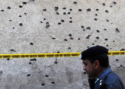 A Pakistani police officer inspects a suicide blast site in Peshawar on August 23, 2009. (A. Majeed/AFP/Getty Images)