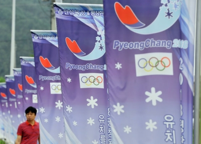 A man walks along a row of banners with the logo of South Korea's mountain resort of Pyeongchang, 180 kms east of Seoul, on July 7, 2011 after the mountain resort was picked to host the 2018 Winter Olympics. (Jung Yeon-Je/AFP/Getty Images) 