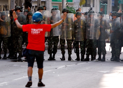 A red shirt protester gestures to members of the Thai military during violent protests on April 13, 2009 in Bangkok, Thailand. (Paula Bronstein/Getty Images)