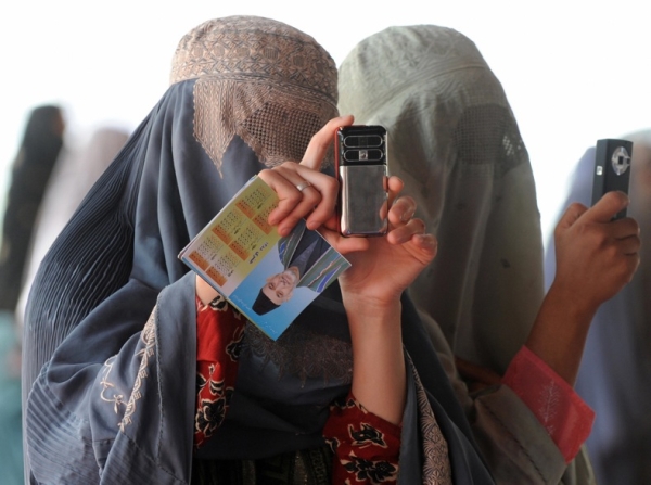 Burqa-clad women take pictures with their mobile phones at an election rally for President Karzai in Kandahar on August 16. (Banaras Khan/AFP/Getty Images)