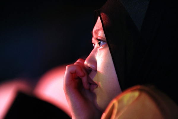A young Malaysian woman watches contestants perform in Malaysia's reality TV competiton Young Imam in Kuala Lumpur on July 30, 2010. (Saeed Khan/AFP/Getty Images) 