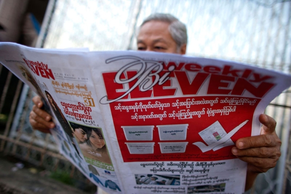 A man reads a newspaper promoting elections on November 5, 2010 in Yangon, Burma. (CKN/Getty Images)