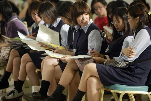 Hong Kong schoolgirls attend a job fair for graduating students. Hong Kong's school system ranked second in the new PISA survey. (Peter Parks/AFP/Getty Images)