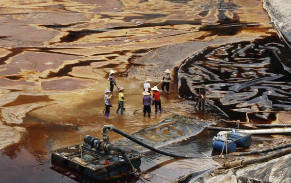 Workers drain polluted water near the Zijin copper mine in Shanghang on July 13, 2010, after pollution from the mine contaminated the Ting River, a major waterway in southeast China&apos;s Fujian province. (STR/AFP/Getty Images)