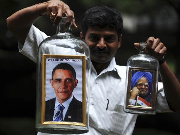 Indian artist Basavaraju S. Gowda holds a jar containing a framed potrait of US president Barack Obama (L) and Indian Prime Minister Manmohan Singh in Bangalore ahead of President Obama&apos;s four-day visit to India on November 4, 2010. (DibyangshuI Sarkar/AFP/Getty Images)