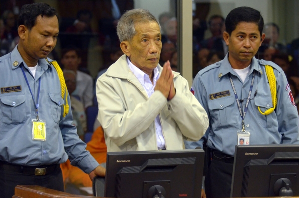 A handout photo taken and released by the Extraordinary Chamber in the Courts of Cambodia (ECCC) on February 3, 2012 shows fomer Khmer Rouge prison chief Kaing Guek Eav — better known as Duch (C) — greeting judges in the courtroom at the ECCC in Phnom Penh. (Nhet Sokheng/AFP/Getty Images)