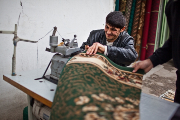 A shop boy helps to measure and trim carpets, mostly produced in China or Turkey, that are sold by the meter. (Sue Anne Tay)