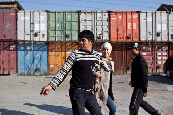 A couple walks by shipping containers that line the parking lot of Dordoi Bazaar, one of the largest in Kyrgyzstan. (Sue Anne Tay)
