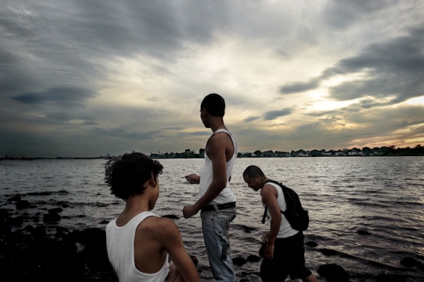 From left to right, Joshua Vatthanavong, 11, Joey Vatthanavong, 16, and Sanet Kek, 28, fish without poles at Ferry Point Park in The Bronx, N.Y. (Pete Pin)