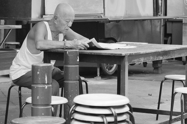 A man reads the morning newspaper in Chinatown, Singapore on September 18, 2012. (beegee49/Flickr)