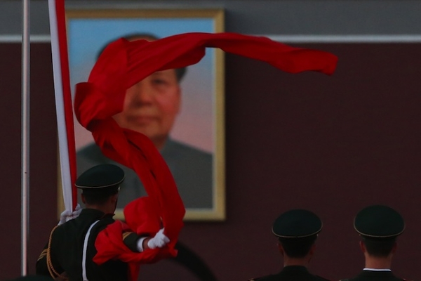 A paramilitary police officer collects the Chinese national flag during the flag-lowering ceremony at Tiananmen Square on November 13, 2012. (Feng Li/Getty Images)