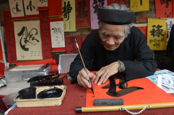 A calligrapher writes down best wishes for the lunar new year or Tet in Vietnamese, for customers outside the Temple of Literature in downtown Hanoi, Vietnam on February 8, 2013. (Hoang Dinh Nam/AFP/Getty Images)