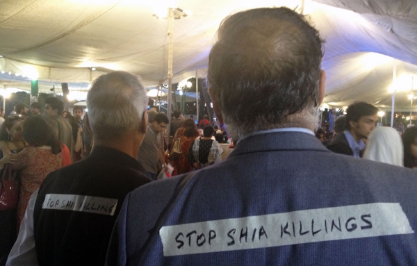 Attendees wearing signs that read "Stop Shia Killings" were a reminder of the troubles impinging on the Festival. (Annie Ali Khan)