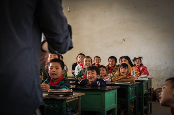 A classroom full of children smile and listen attentively to their teacher in Jizushan, Yunnan Province, China on March 6, 2013. (James Moallem)