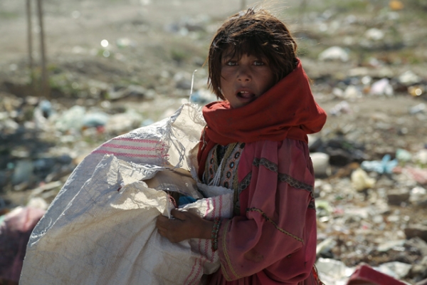 A young nomad girl looks on as she searches amongst the garbage for iron and plastic items to sell in Ghazni, Afghanistan on May 28, 2013. (Rahmatullah Alizada/AFP/Getty Images)
