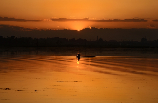 A Kashmiri fisherman paddles his boat during sunset on Dal Lake in Srinagar, India on May 29, 2013. (Tauseef Mustafa/AFP/Getty Images)