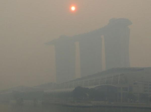 The mid-morning sun struggles to shine through a thick smoke haze above the three towers of the Marina Bay Sands casino resort on Singapore, Friday June 21, 2013. (Geoff Spencer)