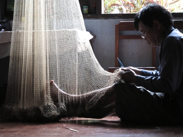 A village chief mends his fishing net in Ban Pong Song, Laos on June 5, 2013. (Steel Wool/Flickr)