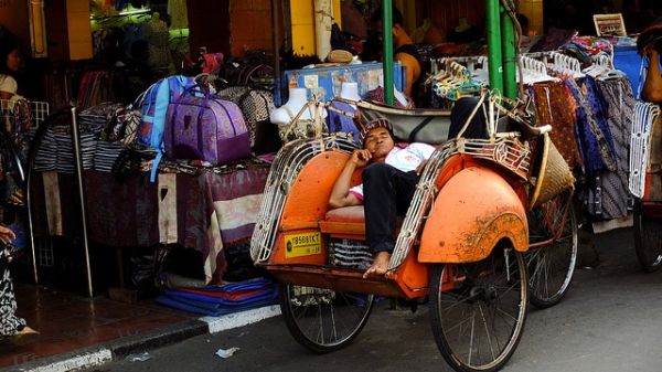 A man reclines in his seat and takes a quick nap alongside a market street in Yogyakarta, Indonesia on June 23, 2013. (Kurniawan Gunadi/Flickr)