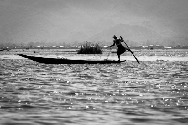 A fisherman balances precariously while rowing with his legs in Nyaung Shwe, Myanmar on May  9, 2013. (Fabio/Flickr)