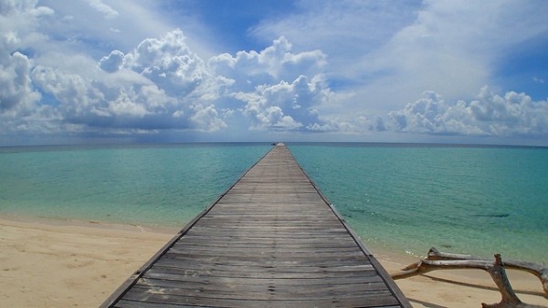 A boardwalk takes visitors over crystal clear waters in Indonesia on November 10, 2013. (Stephen Boak/Flickr) 